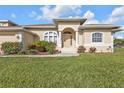 Beautiful home featuring an arched entryway with decorative columns and lush landscaping at 235 Tournament Rd, Rotonda West, FL 33947