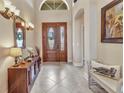 The foyer is enhanced by decorative tile floors and features a wood door with sidelights and transom at 24260 Westgate Blvd, Port Charlotte, FL 33980