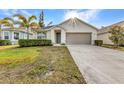Charming single-story home featuring well-kept landscaping, palm tree, and a two-car garage at 25340 E Lenox Cir, Punta Gorda, FL 33950