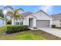 Charming single-story home featuring well-kept landscaping, palm tree, and a two-car garage at 25340 E Lenox Cir, Punta Gorda, FL 33950