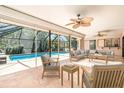Relaxing screened-in porch featuring comfortable seating and a view of the sparkling pool at 2621 Via Veneto Dr, Punta Gorda, FL 33950