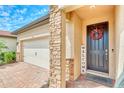 Inviting front door with a welcoming wreath, brick column, and well-maintained landscaping creates a warm entry at 264 Soliera St, Nokomis, FL 34275