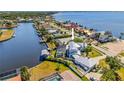 Aerial view of waterfront home with pool, boat dock, and lush landscaping on a sunny day at 310 Severin Se Rd, Port Charlotte, FL 33952