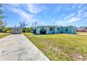 Charming blue house with a well-kept lawn and a shed, showcasing ample outdoor space at 312 Darst Ave, Punta Gorda, FL 33950