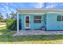 Welcoming front entrance featuring a brick paver patio and a bright blue facade at 312 Darst Ave, Punta Gorda, FL 33950