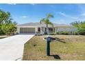 Charming home with well-maintained landscaping, concrete driveway, and a decorative mailbox at 4053 Joseph St, Port Charlotte, FL 33948