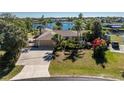 Waterfront property with a lush lawn and gardens leading to tranquil canal views and a large private driveway at 4438 Meager Cir, Port Charlotte, FL 33948
