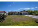 Inviting single-story home with a well-manicured lawn, attached garage, and cozy front porch at 509 Beal Nw St, Port Charlotte, FL 33952