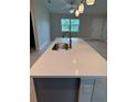 Close-up on kitchen island with quartz countertop, stainless steel sink, and stylish pendant lighting at 5342 Wagon Wheel Dr, North Port, FL 34291