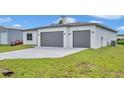 New construction home featuring a two-car garage and modern design in a well-maintained lawn at 551 Crandall Nw St, Port Charlotte, FL 33952