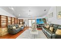 Open living area with hardwood floors, built-in shelving, and sliding glass doors, offering natural light and stylish decor at 5705 44Th E Ave, Bradenton, FL 34203
