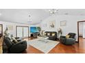 Bright living room with vaulted ceilings, modern lighting, and comfortable seating on wood floor, enhancing a spacious feel at 5705 44Th E Ave, Bradenton, FL 34203