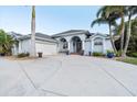 Charming single-story home featuring a three-car garage, an elegant front entrance, and lush landscaping at 1091 Rotonda Cir, Rotonda West, FL 33947