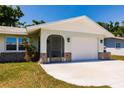 Attached garage with white door and stone accents, complemented by a concrete driveway and manicured lawn at 1357 Nimrod St, Port Charlotte, FL 33952