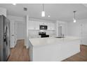 Bright kitchen features white cabinets, stainless steel appliances, and an island with bar seating at 1589 Boswell St, North Port, FL 34288