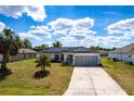 Charming single-story home with a two-car garage, solar panels and well-manicured front lawn at 1721 Nicollett Ave, North Port, FL 34286