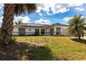 Single-story home with solar panels, featuring a well-maintained yard and a functional two-car garage at 1721 Nicollett Ave, North Port, FL 34286