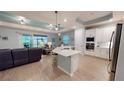 Open-concept kitchen featuring a large island, stainless steel appliances, and a view of the living room at 17420 Jadestone Ct, Venice, FL 34293