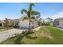 Lovely one-story home with a two-car garage, manicured landscaping, and a brick-paved driveway at 1796 W Palms Dr, Port Charlotte, FL 33953