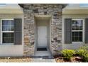 Inviting entryway showcasing stone accents, a neutral-colored front door, and sidelight windows at 1796 W Palms Dr, Port Charlotte, FL 33953