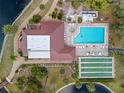 Aerial view of the community pool, shuffleboard, and clubhouse surrounded by landscaping and water features at 23465 Harborview Rd # 915, Punta Gorda, FL 33980
