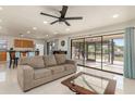 Comfortable living room featuring neutral décor, tile floors, fan, and sliding glass doors to outdoor area at 2368 Pellam Blvd, Port Charlotte, FL 33948