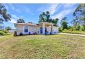 Lovely single-story home boasts a blue front door, manicured lawn, mature trees, and a one-car garage at 2679 Pascal Ave, North Port, FL 34286