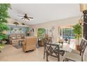 Bright living and dining area with tile floors, ceiling fan, and views of the pool at 3078 Mancini Ter, Punta Gorda, FL 33983