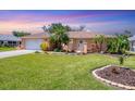 Charming single-story home featuring lush lawn, well-manicured landscaping, and a welcoming front entrance at 3287 Meadow Run Cir, Venice, FL 34293