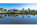 Waterfront home with boat dock and lift offering picturesque water views under a sunny sky at 347 Portofino Dr, Punta Gorda, FL 33950