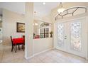 Bright foyer with high ceilings, decorative windows, tile flooring, and view into the dining area at 3614 January Ave, North Port, FL 34288