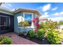 Home entrance features brick walkway, tropical landscaping, and a screen enclosed doorway at 5309 Shell Mound Cir, Punta Gorda, FL 33982