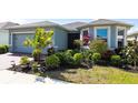 Single-story home with lush landscaping including bushes, palms and colorful plants at 5309 Shell Mound Cir, Punta Gorda, FL 33982