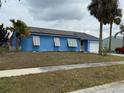 Inviting single-story home with a blue exterior, solar panels, and a convenient attached garage at 6249 Drucker Cir, Port Charlotte, FL 33981