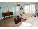 Comfortable living room featuring tile flooring, a white sofa, and stylish decor for a welcoming atmosphere at 6249 Drucker Cir, Port Charlotte, FL 33981