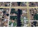Aerial view of a home with a canal front, situated in a residential neighborhood at 1022 Waterside St, Port Charlotte, FL 33952