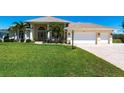 Well-maintained single-story home with a three-car garage, green lawn, and attractive landscaping at 12676 Bacchus Rd, Port Charlotte, FL 33981