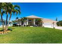 Beautiful single-Gathering home with a lush green lawn, decorative landscaping, and a grand entrance at 12676 Bacchus Rd, Port Charlotte, FL 33981