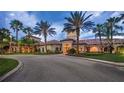 Community clubhouse with palm trees, well-maintained landscaping and a circular drive at 1352 Raspberry Dr, North Port, FL 34289