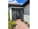 Screened entryway with brick flooring and view into a neutrally painted foyer at 1352 Raspberry Dr, North Port, FL 34289