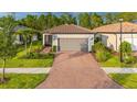 Charming single-story home featuring a tile roof, brick driveway, and well-manicured landscaping at 1352 Raspberry Dr, North Port, FL 34289