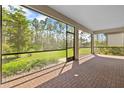 A spacious screened patio featuring brick floors and great views of the green backyard at 1352 Raspberry Dr, North Port, FL 34289