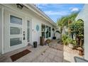 Welcoming entryway featuring a tiled porch and a lush tropical garden, creating a serene and inviting ambiance at 1425 Appian Dr, Punta Gorda, FL 33950
