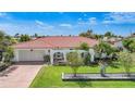 Charming single-story home with a well-manicured lawn, tiled roof, and an inviting front entrance with arched accents at 1425 Appian Dr, Punta Gorda, FL 33950