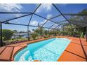 Inviting screened-in pool area with a sparkling pool and views of the tranquil canal for relaxation and enjoyment at 1425 Appian Dr, Punta Gorda, FL 33950