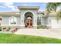 Inviting home entrance with double doors, arched windows, and well-manicured landscaping at 15618 Aqua Cir, Port Charlotte, FL 33981
