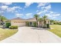 Attractive one-story home with an attached garage and beautiful landscaping including tropical palm trees and shrubs at 18379 Edgewater Dr, Port Charlotte, FL 33948