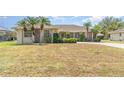 Lovely one-story home showcasing a green lawn, tropical palm trees, and manicured shrubbery accentuating the facade at 18379 Edgewater Dr, Port Charlotte, FL 33948