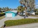 Brightly painted home with well-maintained landscaping, mature palm trees, and a spacious driveway at 1960 W Marion Ave, Punta Gorda, FL 33950