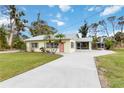 Inviting single-story home showcasing a spacious driveway, lush lawn, and sunroom at 212 Gulf Ave, Nokomis, FL 34275